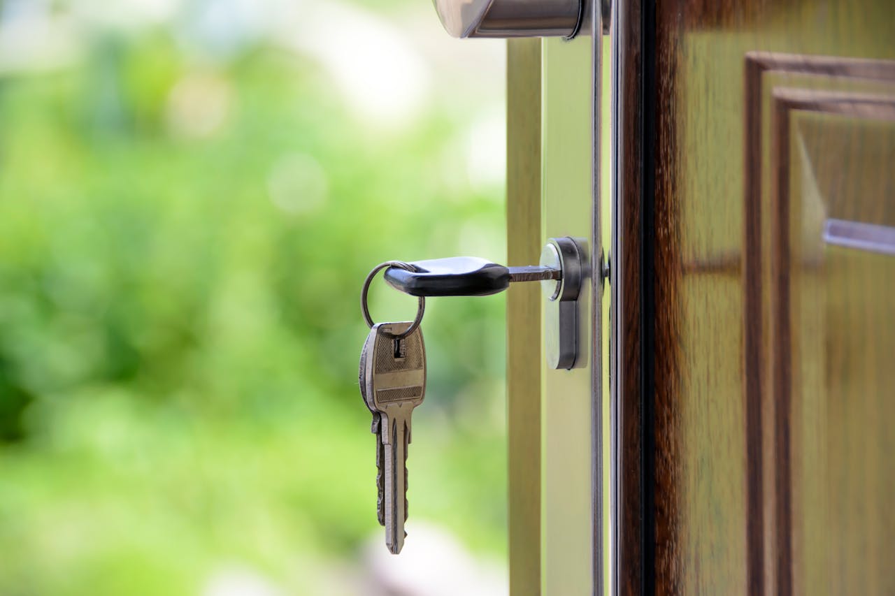 creative Key inserted in door lock against a blurred green background, symbolizing security and real estate.